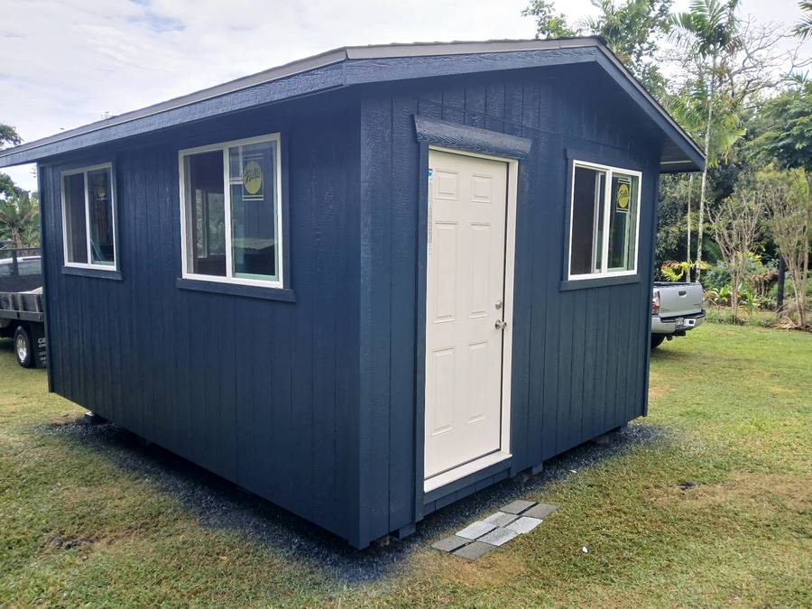 Navy shed with three windows and a white entry door